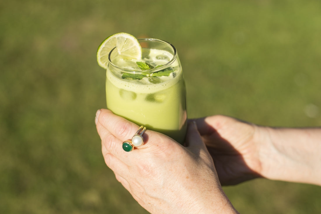 Hand holding a wheatgrass smoothie